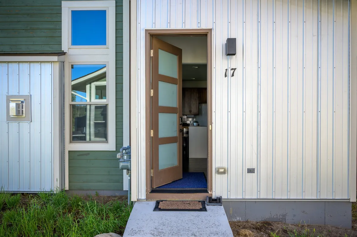 The front door and entryway of the property, complete with a cheerful entrance mat and well-kept façade. The setting is both inviting and practical, highlighting the transition from outdoor adventures to the comfort of home.